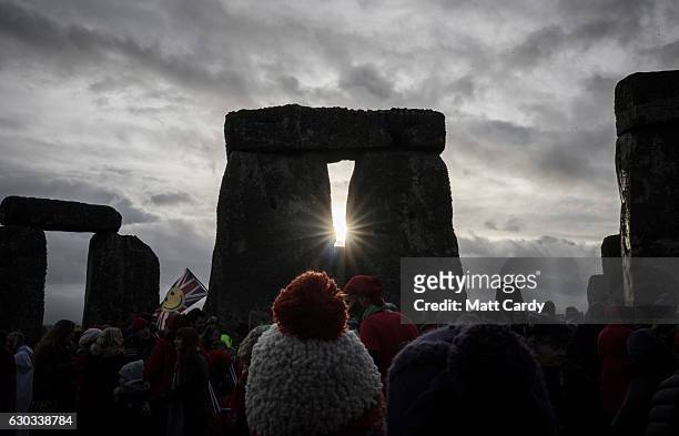 People look towards the sun as druids, pagans and revellers gather at Stonehenge, hoping to see the sun rise, as they take part in a winter solstice...