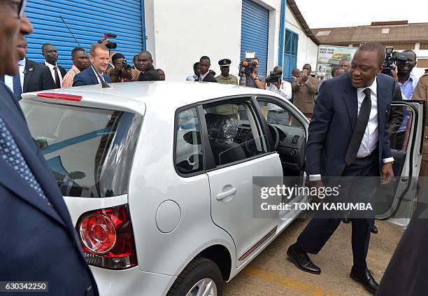 Kenyan President Uhuru Kenyatta gets out a Polo Vivo after testing it with Volkswagen Brand CEO Herbert Diess at the newly opened assembly line of...