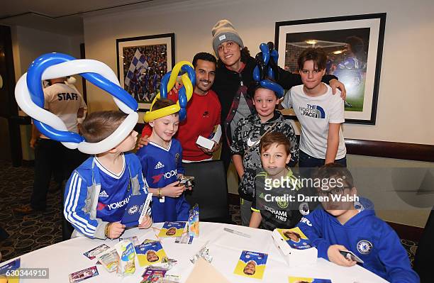 Pedro and David Luiz pose with young Chelsea fans as they attend the club's children's Christmas party at Stamford Bridge on December 21, 2016 in...
