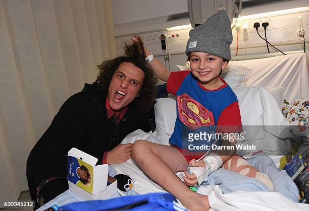 David Luiz of Chelsea delivers Christmas presents to James Middlehurst at The Chelsea and Westminster hospital on December 21, 2016 in London,...