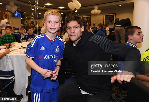 Marcos Alonso poses with a young Chelsea fan as they attend the club's children's Christmas party at Stamford Bridge on December 21, 2016 in London,...