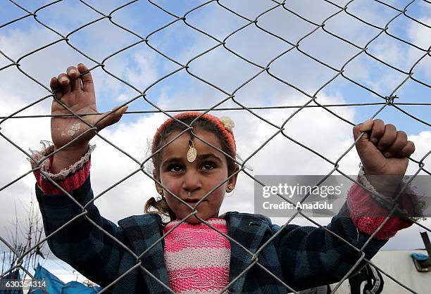 Syrian refugee girl is seen behind the wire fences at a refugee camp in the Torbali district of Izmir, Turkey on December 21, 2016. Doctors WorldWide...