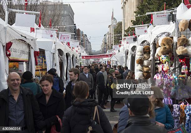 People shop at the Downtown Holiday Market for Christmas gifts and other holiday items in Washington, DC, December 21, 2016. / AFP / SAUL LOEB