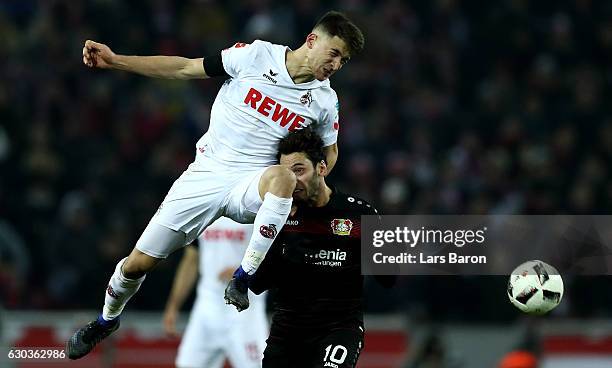 Salih Oezcan of Koeln challenges Hakan Calhanoglu of Bayer Leverkusen during the Bundesliga match between 1. FC Koeln and Bayer 04 Leverkusen at...