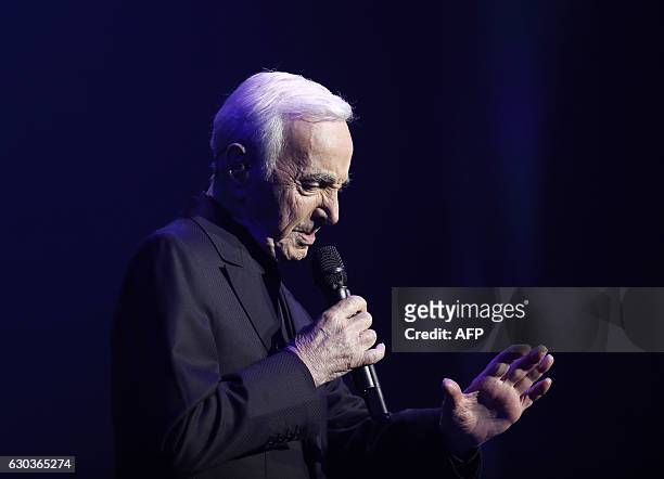 French-Armenian singer Charles Aznavour performs during a concert at the Palais des Sports in Paris on December 21, 2016. / AFP