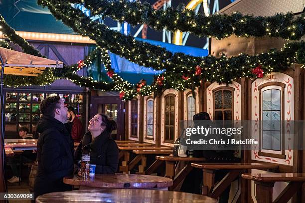 Couple share a joke in a bar at the Winter Wonderland in Hyde Park on December 21, 2016 in London, England. Winter Wonderland is an annual event in...