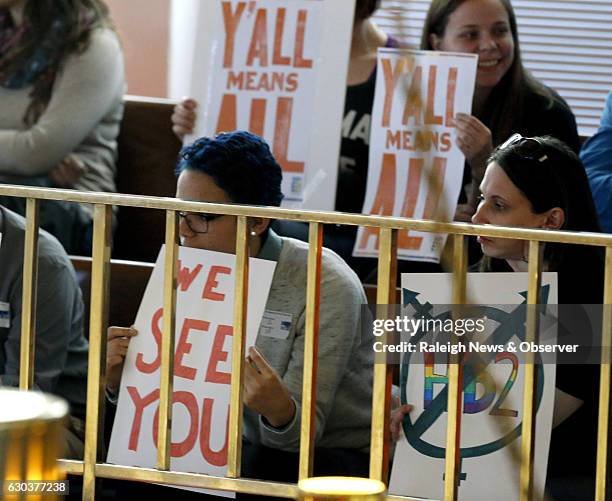 Opponents of HB2 hold signs inside the North Carolina Senate chambers gallery as the North Carolina General Assembly convenes for a special session...