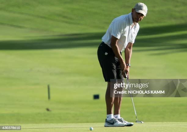 President Barack Obama putts on the 18th green at the Kapolei Golf Club in Kapolei on December 21, 2016 during his annual Christmas vacation in...