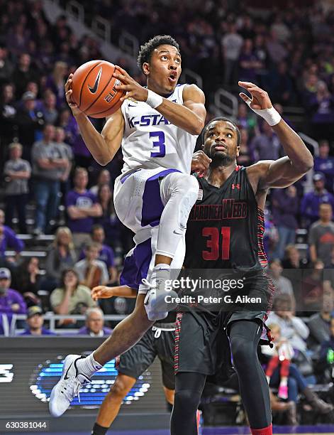 Guard Kamau Stokes of the Kansas State Wildcats drives to the basket past center L'Hassane Niangane of the Gardner-Webb Bulldogs during the second...