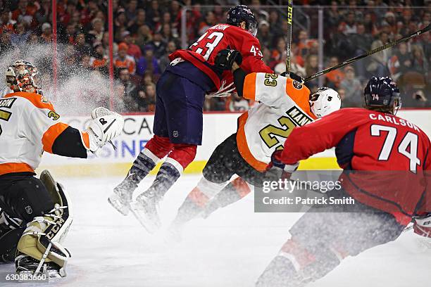 Tom Wilson of the Washington Capitals checks Brandon Manning of the Philadelphia Flyers during the third period at Wells Fargo Center on December 21,...