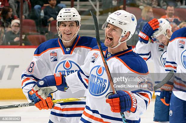 Matt Hendricks of the Edmonton Oilers celebrates with teammate Brandon Davidson after his second period goal against the Arizona Coyotes at Gila...