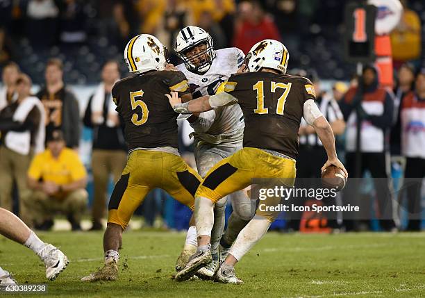 Harvey Langi puts pressure on Wyoming Josh Allen during the San Diego Credit Union Poinsettia Bowl game between the BYU Cougars and the Wyoming...