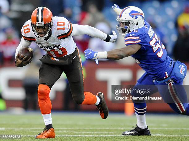 Quarterback Robert Griffin III of the Cleveland Browns carries the ball out of the tackle of linebacker Jerry Hughes of the Buffalo Bills during a...