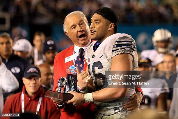 President of the San Diego County Credit Union Poinsettia Bowl Ted Tollner congratulates Harvey Langi of the Brigham Young Cougars for winning the...