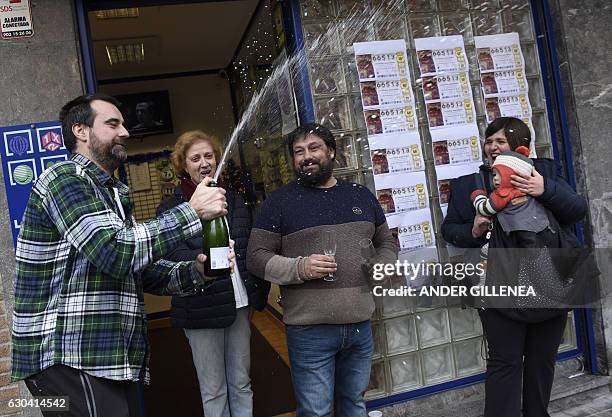 Spanish national lottery shop owners and lottery winners David Lobato Jose Vadillo celebrate the sale of 50 first prize tickets in the Spanish...