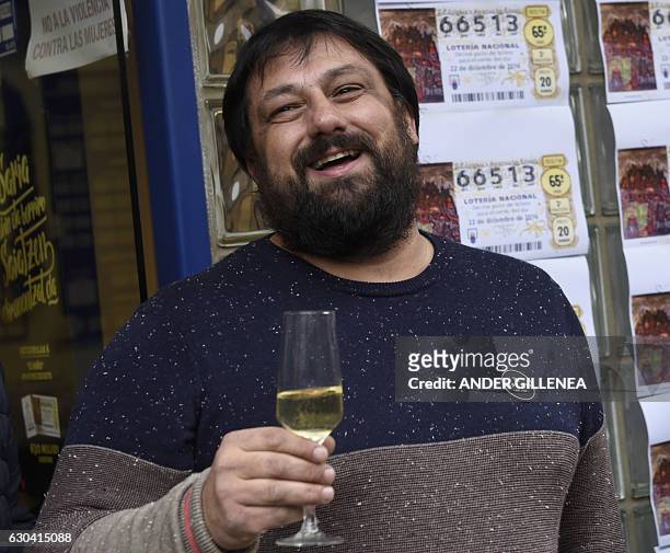 Spanish national lottery shop owner and lottery winner David Lobato celebrates the sale of 50 first prize tickets in the Spanish Christmas lottery,...