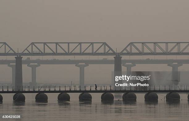 Indian men cross ganges River on a temporary pantoon tank bridge , during foggy weather, in Allahabad on December 22,2016.