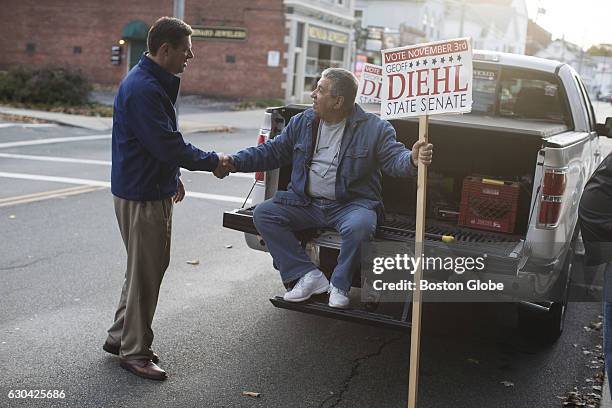 Republican State Representative Geoff Diehl greets supporter Jack Lenoci, right, before a campaign stop with Massachusetts Governor Charlie Baker in...