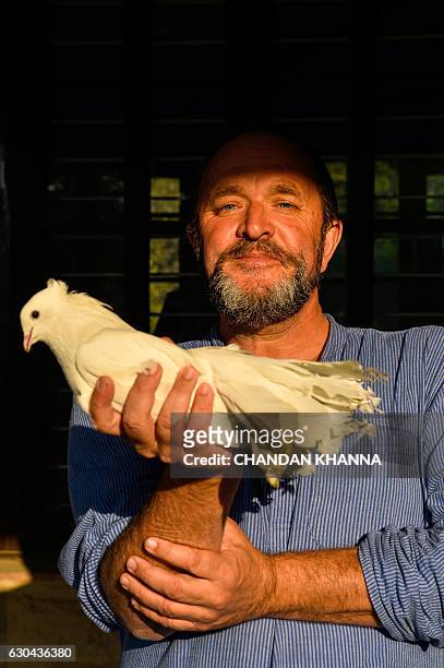 In this photograph taken on December 16 Scottish historian and writer William Dalrymple holds one of his pigeons at his farm house in New Delhi. Many...