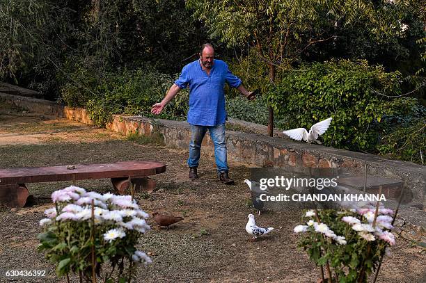 In this photograph taken on December 16 Scottish historian and writer William Dalrymple walks amongst his pigeons at his farm house in New Delhi....