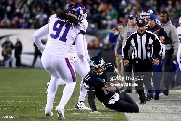 Quarterback Carson Wentz of the Philadelphia Eagles slides out of bounds against middle linebacker Kelvin Sheppard of the New York Giants during the...