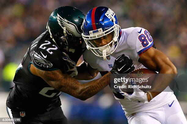 Wide receiver Victor Cruz of the New York Giants catches a pass against cornerback Nolan Carroll of the Philadelphia Eagles during the third quarter...