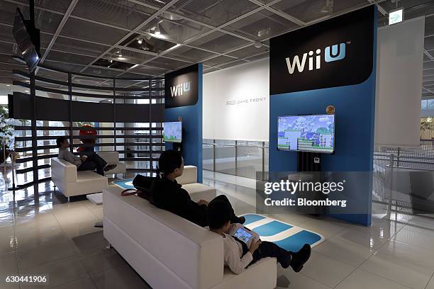 Visitors play Nintendo Co.'s Super Mario Maker video game using the company's Wii U game console controllers at the Nintendo Game Front showroom in...