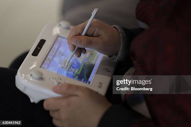 Visitor plays Nintendo Co.'s Super Mario Maker video game using a stylus on the company's Wii U game console controller at the Nintendo Game Front...