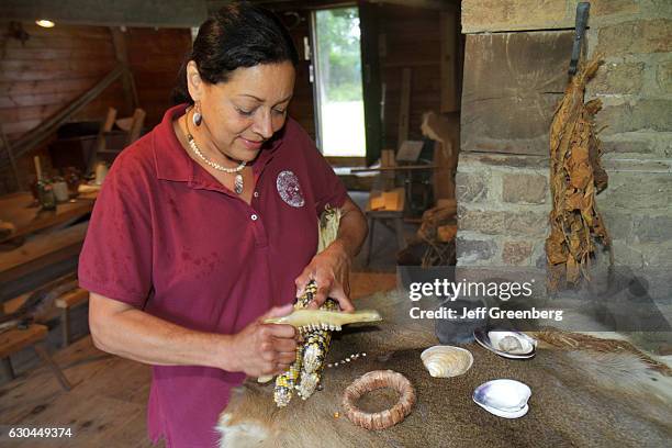 Wampanoag Native American woman demonstrating animal jaw on some corn at Aptucxet Trading Post Museum.