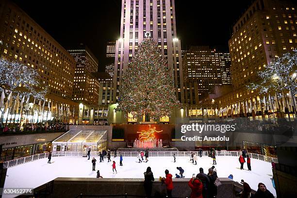 Rockefeller Christmas Tree, at the height of 28,6 meters and weights 14 tons with 50,000 lightbulbs shines over the ice-skating people at Rockefeller...