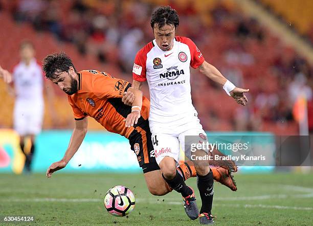 Jumpei Kusukami of the Wanderer is challenged by Thomas Broich of the Roar during the round 22 A-League match between Brisbane Roar and Western...