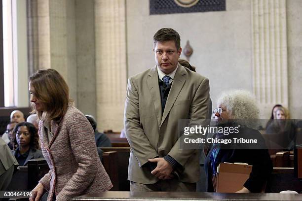 Jason Van Dyke walks past several attorneys including Assistant Attorney General Barbara Greenspan, right, on his way to the bench. Former police...
