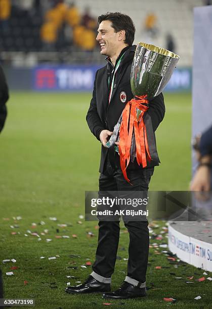 Head coach Vincenzo Montella of AC Milan poses with the trophy after winning the Supercoppa TIM Doha 2016 match between Juventus FC and AC Milan at...