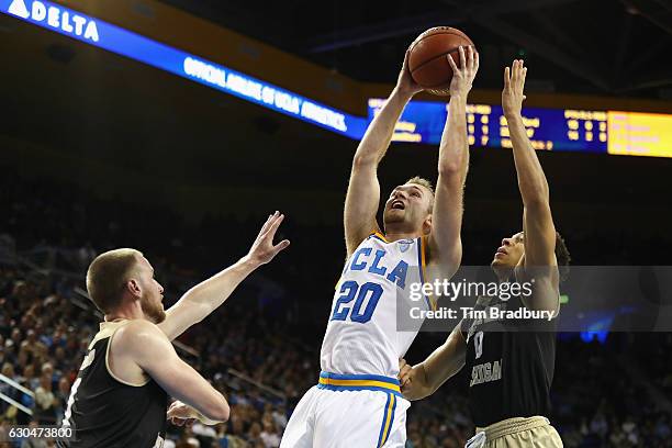 Bryce Alford of the UCLA Bruins drives to the basket against Tucker Haymond and Bryce Moore of the Western Michigan Broncos during the second half of...