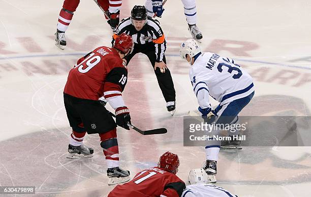 Shane Doan of the Arizona Coyotes and Auston Matthews of the Toronto Maple Leafs prepare to take the opening faceoff from referee Kyle Rehman at Gila...