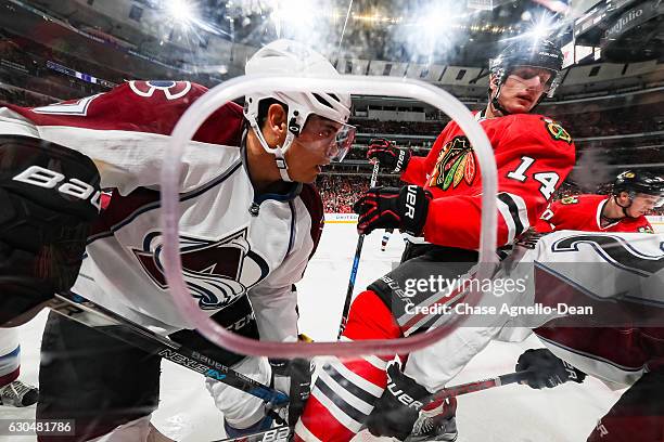 Rene Bourque of the Colorado Avalanche and Richard Panik of the Chicago Blackhawks work to get at the puck by the boards in the second period at the...