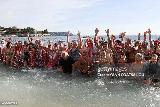 People take part in the traditional Christmas Swim in Monaco on December 24, 2016. / AFP / Yann COATSALIOU