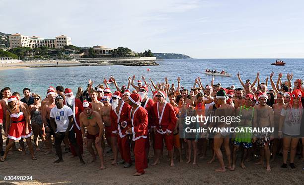 People take part in the traditional Christmas Swim in Monaco on December 24, 2016. / AFP / Yann COATSALIOU