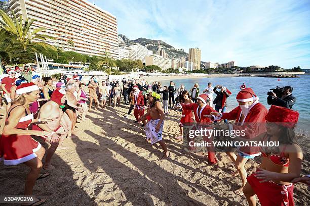People take part in the traditional Christmas Swim in Monaco on December 24, 2016. / AFP / Yann COATSALIOU