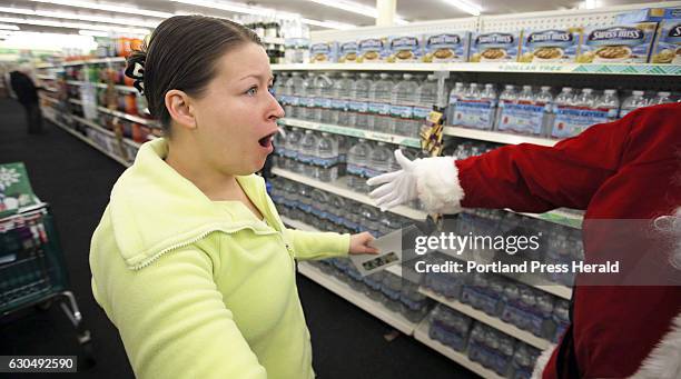 Melissa Delafontaine, of Sanford, reacts with disbelief after realizing Secret Santa Maine just handed her a $100 bill at the Dollar Tree.