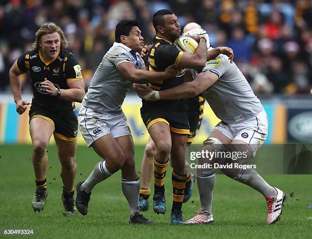 Kurtley Beale of Wasps is held by Ben Tapuai and Dave Attwood during the Aviva Premiership match between Wasps and Bath Rugby at The Ricoh Arena on...