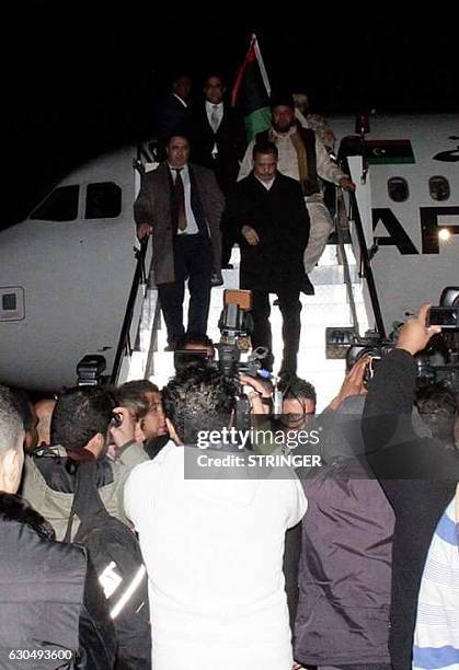 Passengers disembark from an Afriqiyah Airways Airbus A320 upon their arrival at Tripoli's Mitiga airport, on December 24, 2016 a day after two men...