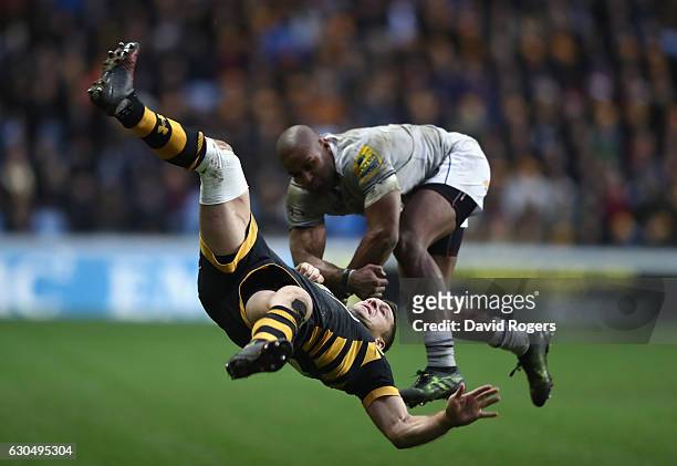 Jimmy Gopperth of Wasps falls as he is challenged by Aled Brew during the Aviva Premiership match between Wasps and Bath Rugby at The Ricoh Arena on...