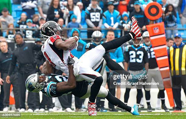 James Bradberry of the Carolina Panthers tackles Julio Jones of the Atlanta Falcons in the 1st quarter during the game at Bank of America Stadium on...
