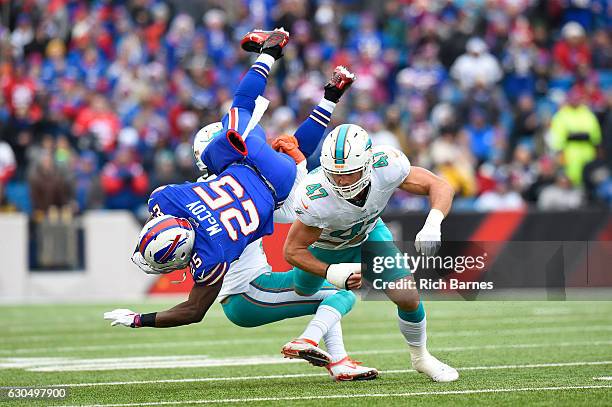 LeSean McCoy of the Buffalo Bills is upended by Michael Thomas of the Miami Dolphins and Kiko Alonso of the Miami Dolphins during the first half at...