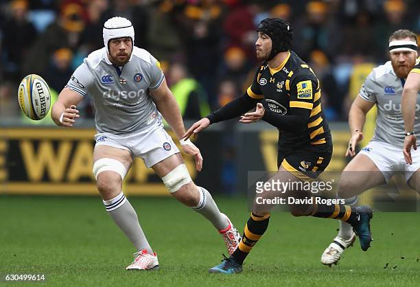 Danny Cipriani of Wasps passes the ball watched by Dave Attwood during the Aviva Premiership match between Wasps and Bath Rugby at The Ricoh Arena on...