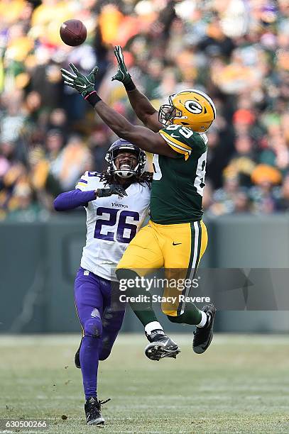 Jared Cook of the Green Bay Packers catches a pass in front of Trae Waynes of the Minnesota Vikings during the second half of a game at Lambeau Field...