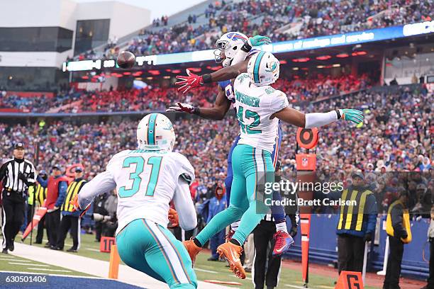 Charles Clay of the Buffalo Bills has a pass broken up by Spencer Paysinger of the Miami Dolphins during the second half at New Era Stadium on...