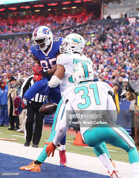 Charles Clay of the Buffalo Bills has a pass broken up by Spencer Paysinger of the Miami Dolphins during the second half at New Era Stadium on...