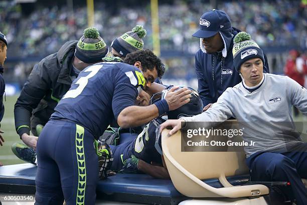 Quarterback Russell Wilson of the Seattle Seahawks tends to wide receiver Tyler Lockett after he was injured after a play against the Arizona...